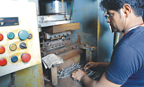 Operator using industrial manufacturing equipment